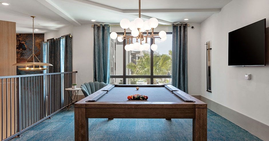 a living room with a pool table and a tv
