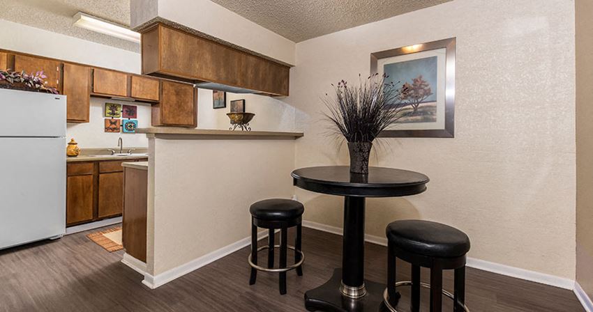 a kitchen with a table and stools in front of a kitchen counter