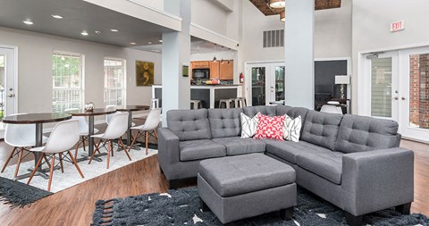 a living room with a gray couch and a table and chairs