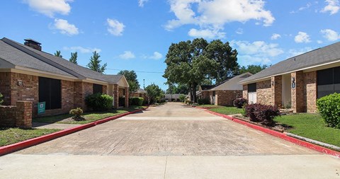 a street with brick houses on either side of a driveway