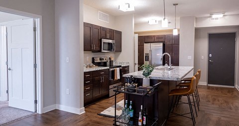 A kitchen with dark wood cabinets and a white island.