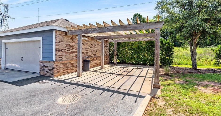 a brick garageArlington at Eastern Shore Centre | Spanish Fort, AL with a wooden porch and a white garage door