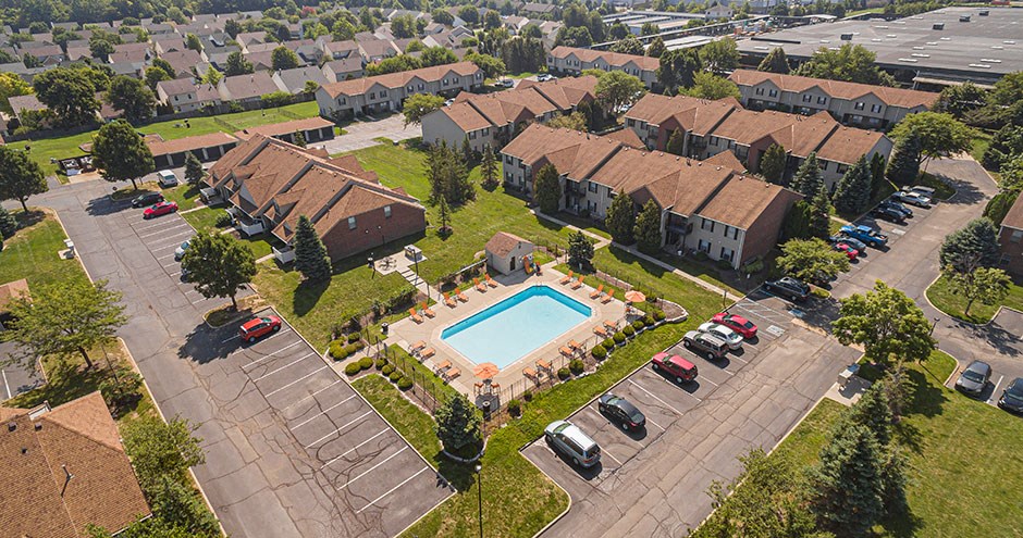 an aerial view of a pool and houses in a neighborhood