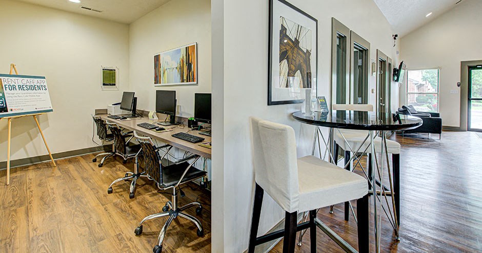 an office with desks and chairs and a table with computers