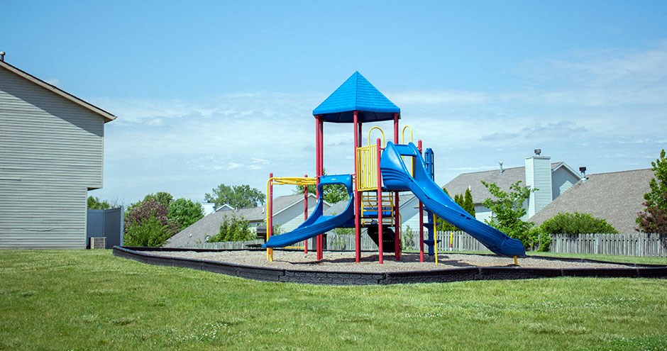 a playground with a blue and red playset in a yard