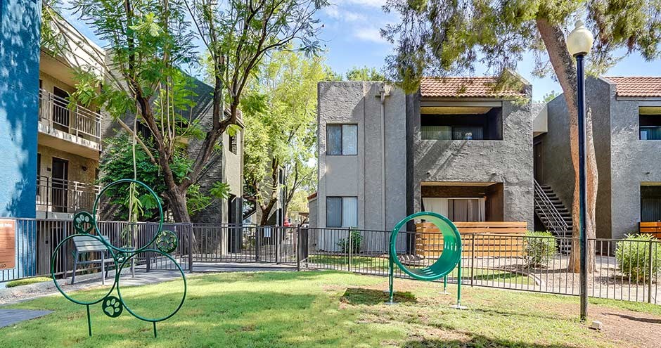 a playground in a park in front of some apartments