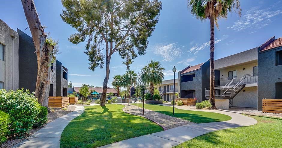 a city street with houses and trees and a sidewalk