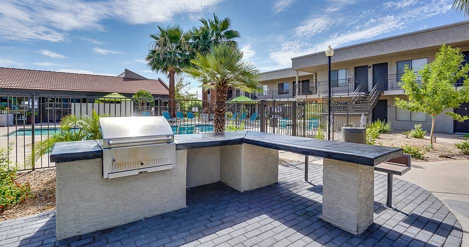 a patio with a grill and a swimming pool