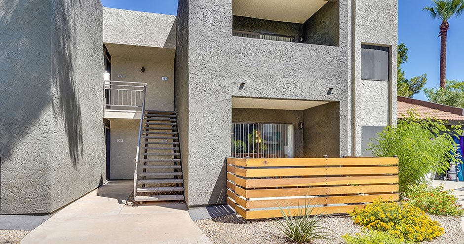 a building with stairs and a wooden bench in front of it