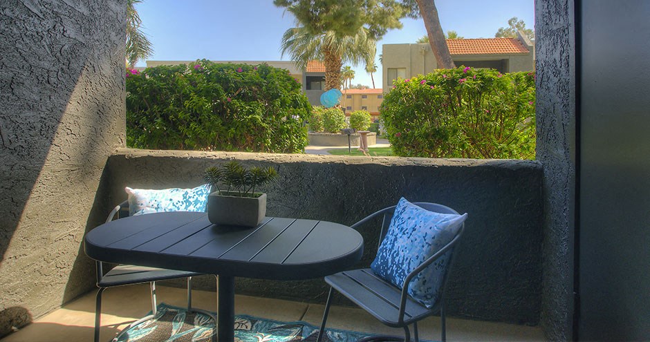 a patio with a table and chairs on a balcony
