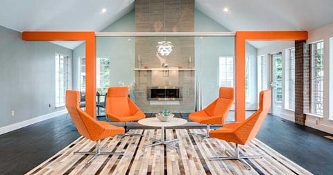 a living room with orange chairs and a fireplace