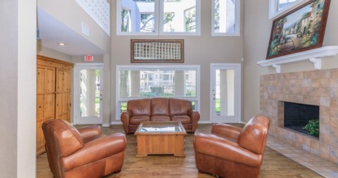 A living room with brown leather chairs and a fireplace.