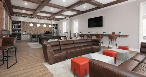 a living room with leather couches and a bar and a television