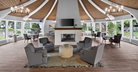 A living room with a fireplace and grey chairs.