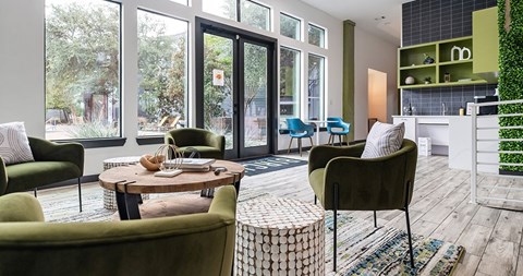 A living room with a green chair and a table with a vase on it.