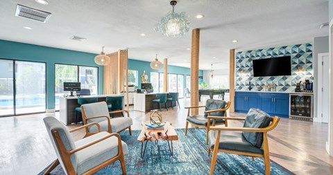 A living room with blue chairs and a television.