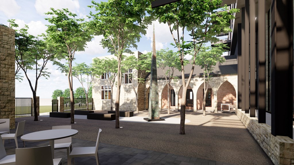 a courtyard with trees and tables and a building in the background