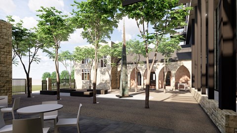 a courtyard with trees and tables and a building in the background