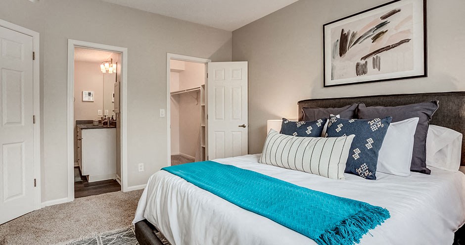 a bedroom with a bed and a bathroom with a sink