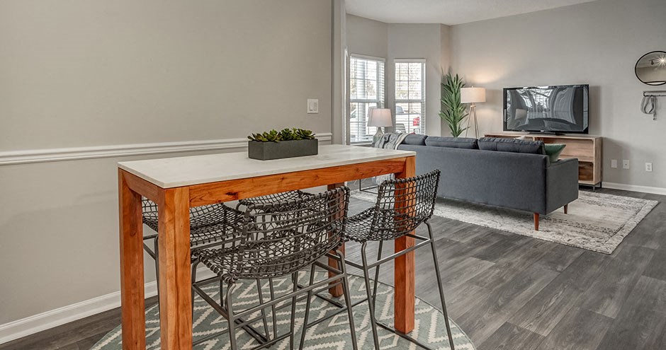 a living room with a wooden table with three chairs