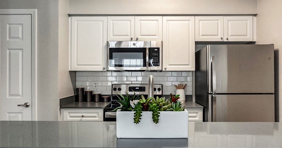 a kitchen with white cabinets and a sink and a microwave