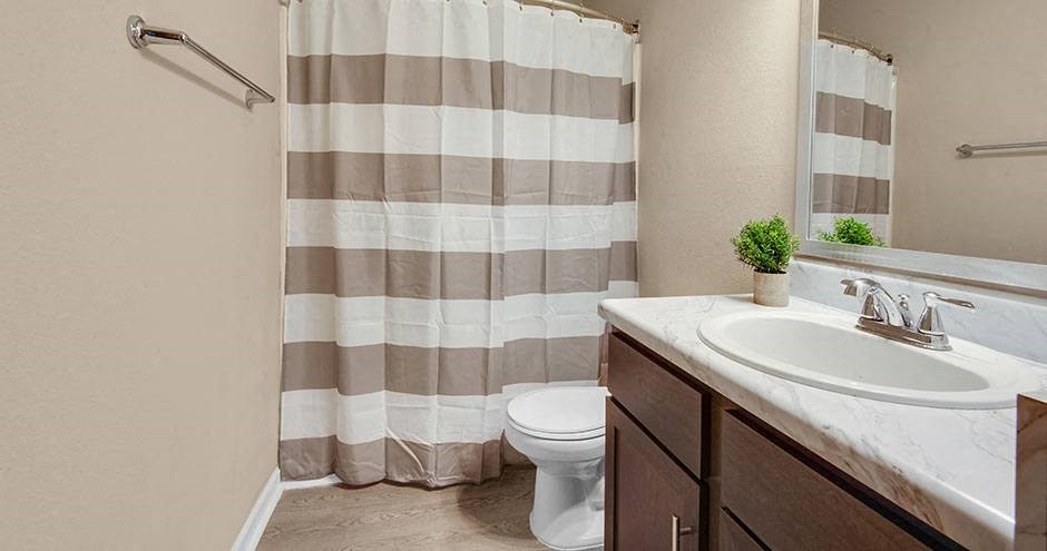 a bathroom with a shower curtain and a sink and a toilet