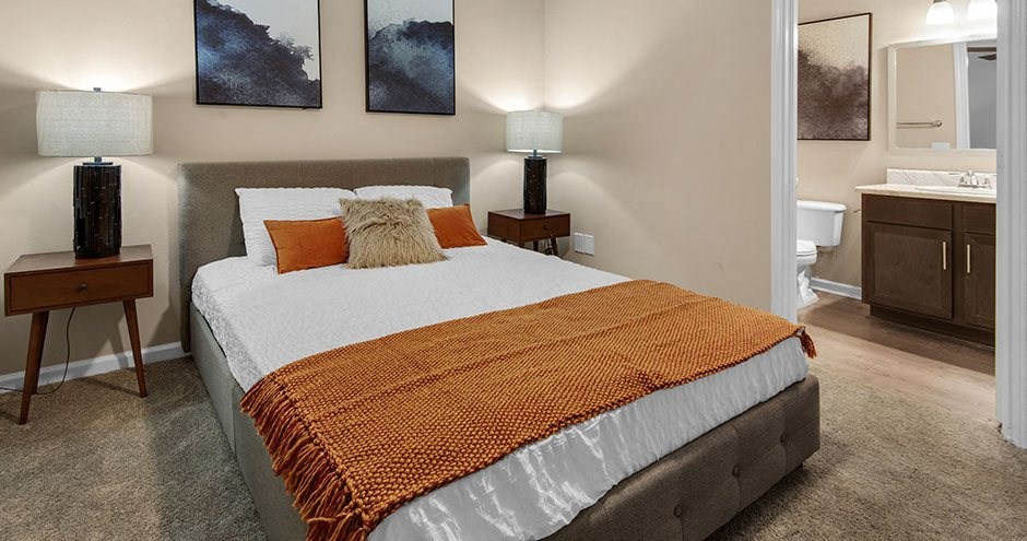 a bedroom with a bed and a bathroom with a sink