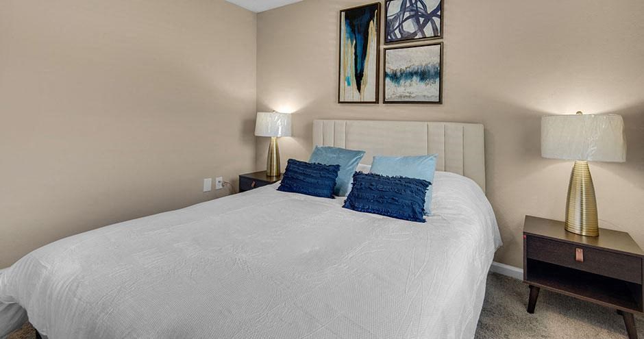 a bedroom with a white bed and two lamps