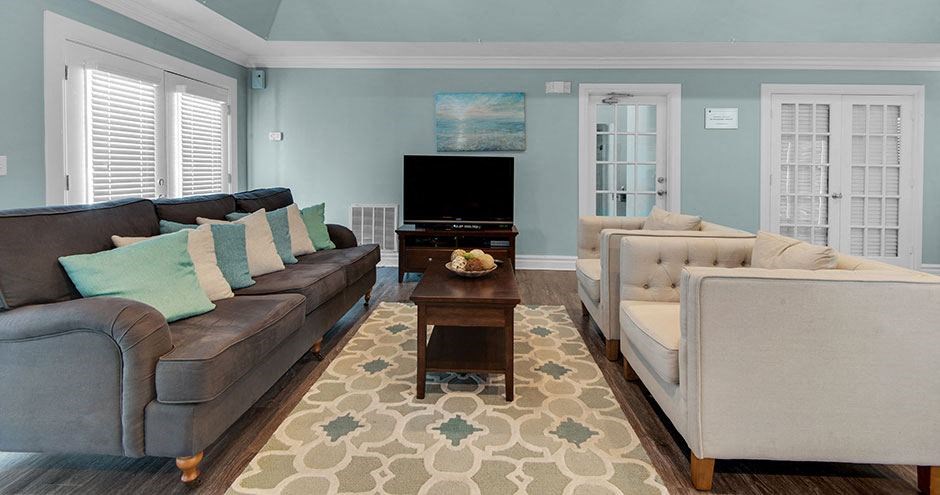 a living room with couches and chairs and a television