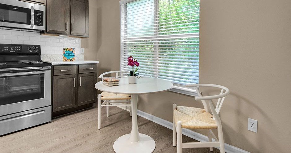 a small kitchen with a white table and chairs
