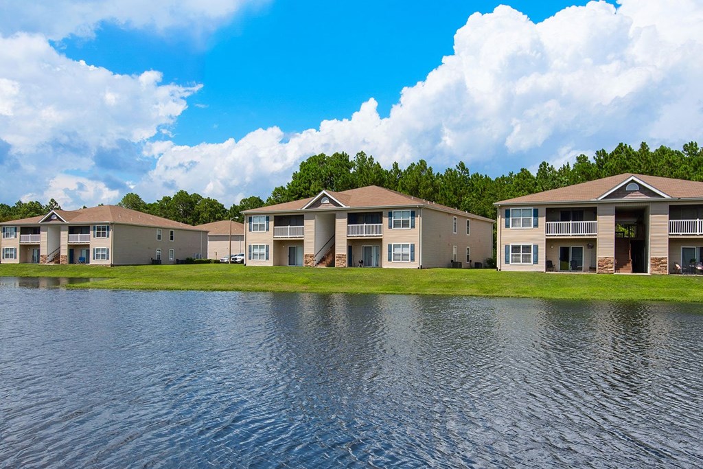 a pond in front of a row of apartment buildings