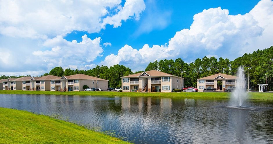 a lake with a fountain in front of a building