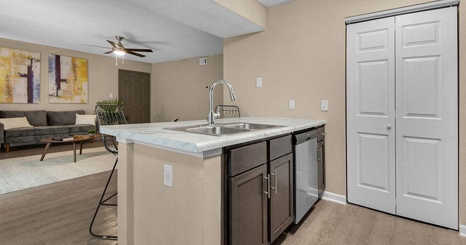 an empty kitchen with a sink and a ceiling fan