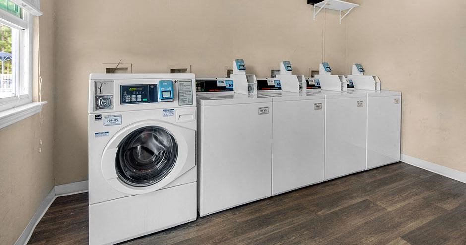a row of washing machines and dryers in a room