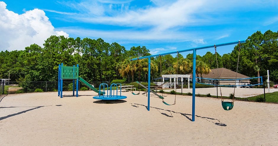 a playground with a swing set and a sandbox