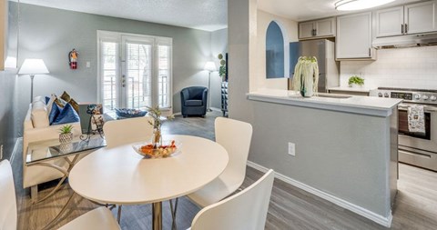 A modern kitchen with a dining table and chairs.