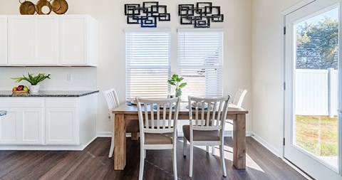 A dining room with a table and chairs.