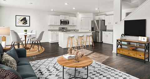 a living room and kitchen with a table and a television