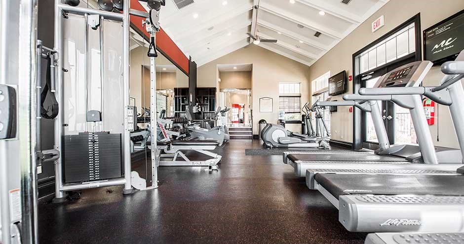 a gym with cardio equipment and weights