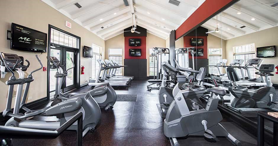 a gym with a lot of treadmills and other exercise equipment