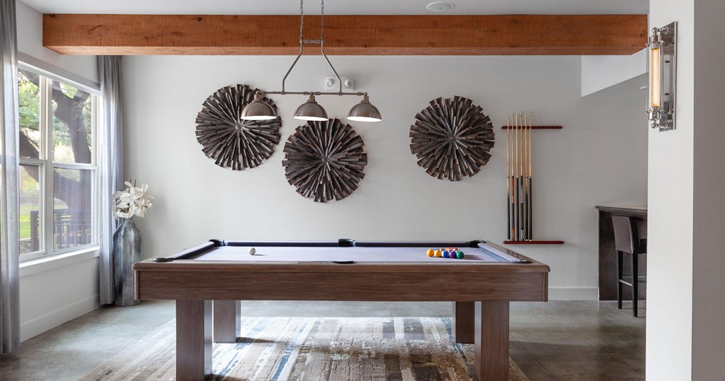a pool table in a living room with decorations on the wall