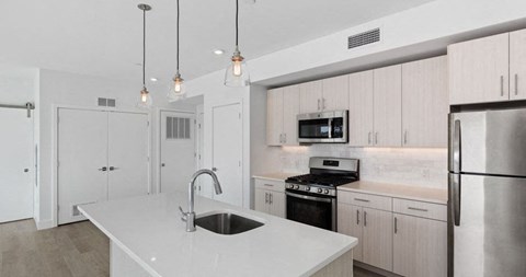 a white kitchen with a sink and a refrigerator