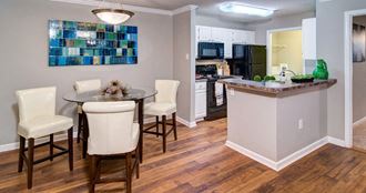 a dining room and kitchen with a table and chairs