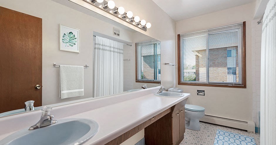 a bathroom with two sinks and a large mirror