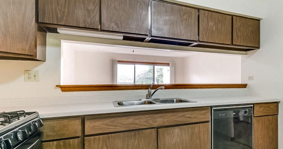a kitchen with wooden cabinets and a sink and a window