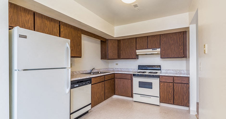 a kitchen with white appliances and wooden cabinets