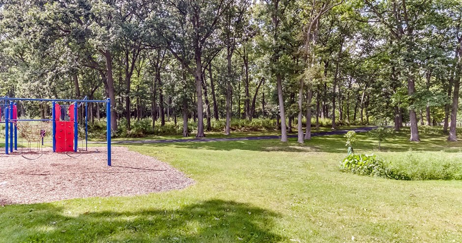 a red swing set in the middle of a park