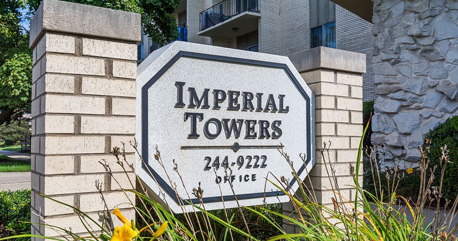 a sign for imperial towers in front of a building