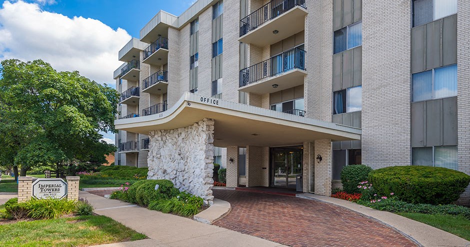 an apartment building with a walkway and a sign in front of it