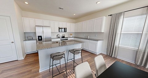 A kitchen with a bar area and two chairs.